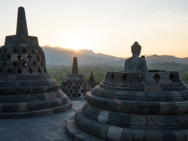 朝日に照らされるインドネシア・ジャワ島のボロブドゥール寺院と仏像の風景