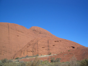 青い空にはえるオルガ岩群の赤い岩壁